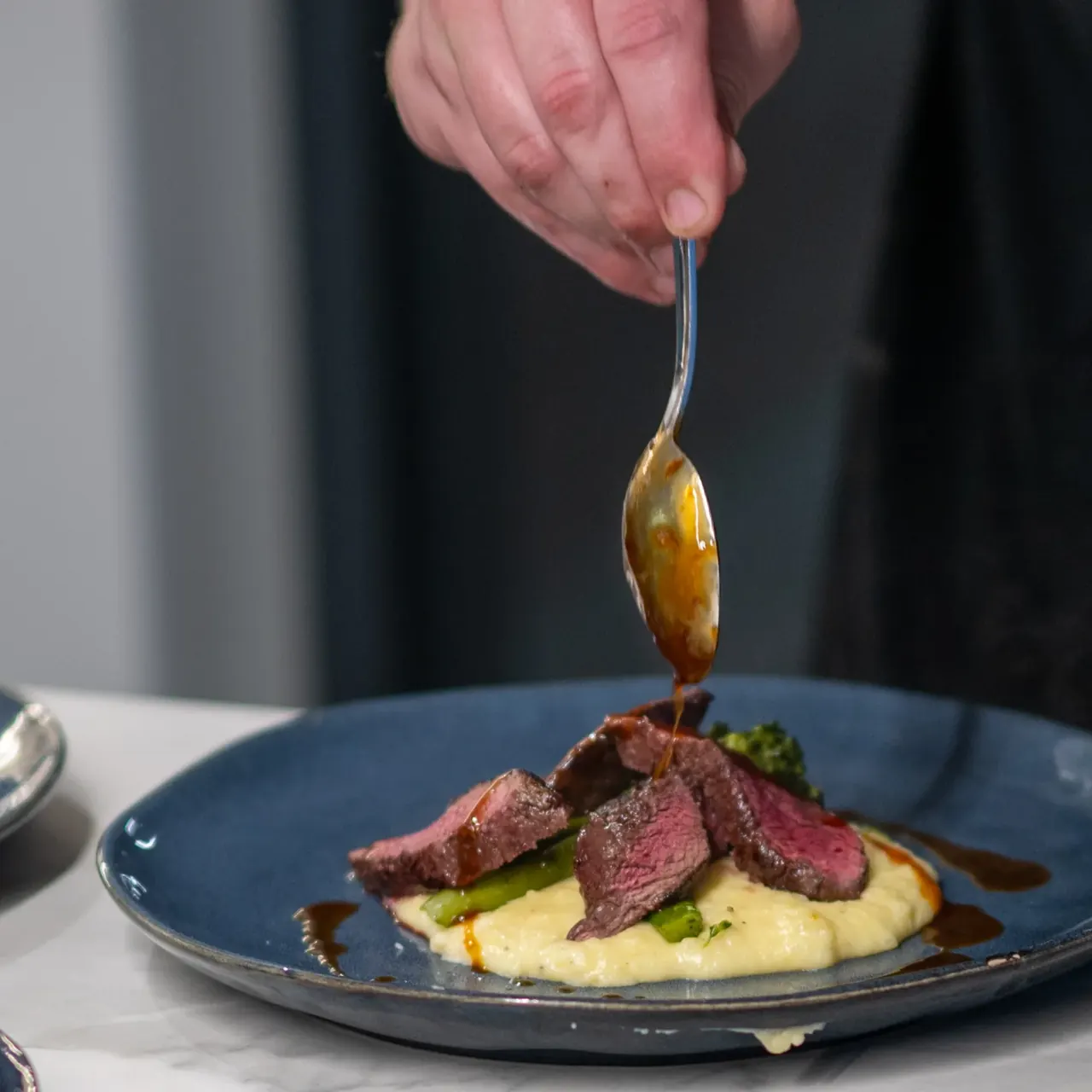 Private chef plating a restaurant-quality course for a degustation