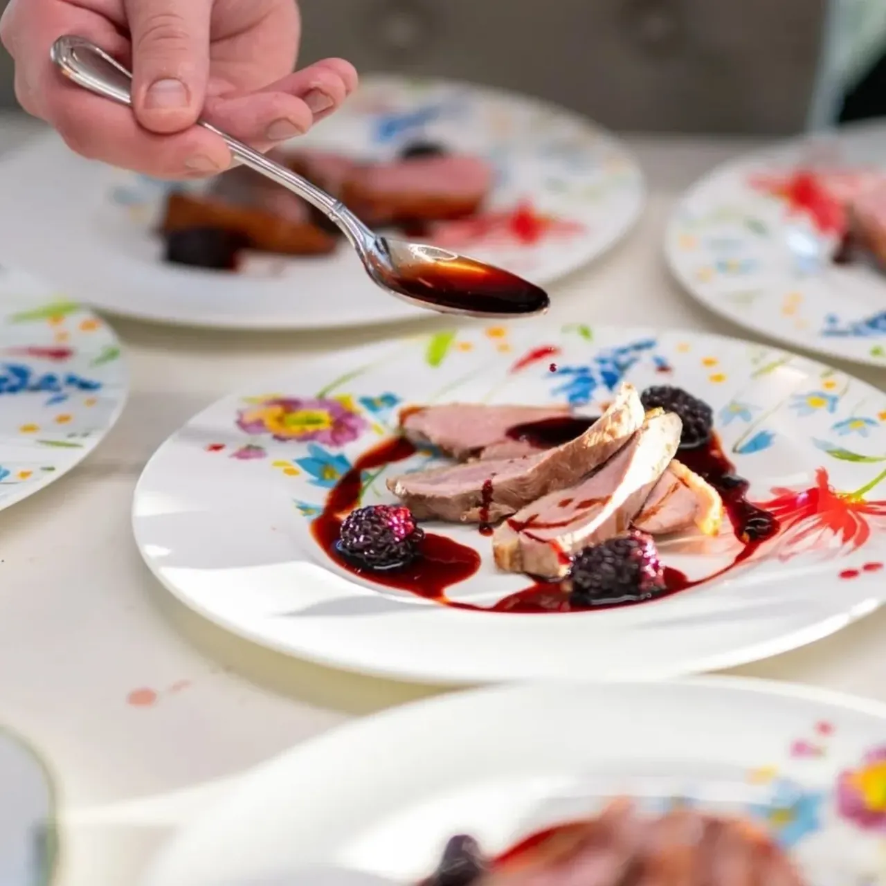 Chef adding sauce to a plated dish