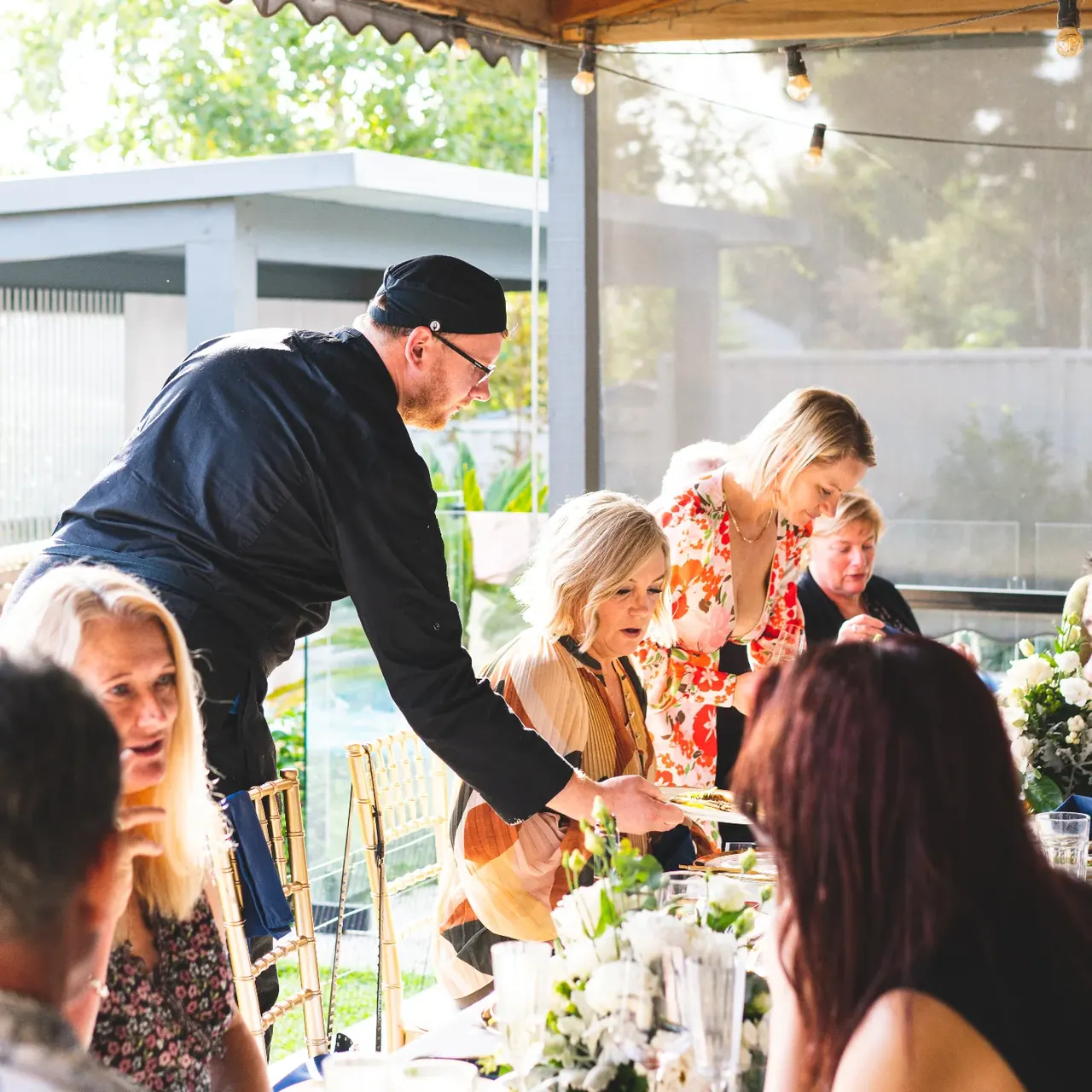 Private chef serving guests at an outdoor dining experience